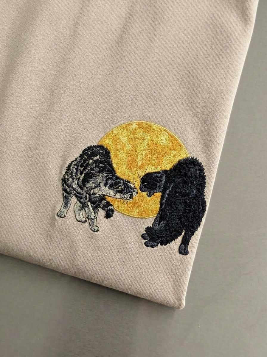 TWO CATS FIGHTING AGAINST THE SILHOUETTE OF THE MOON